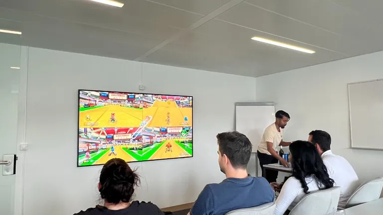 Mitarbeitende von Bosshard & Partner spielen ein Computerspiel